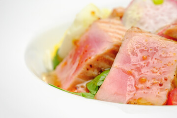 Tuna salad with egg, tomatoes and salad on a white plate. Lunch at the restaurant.
