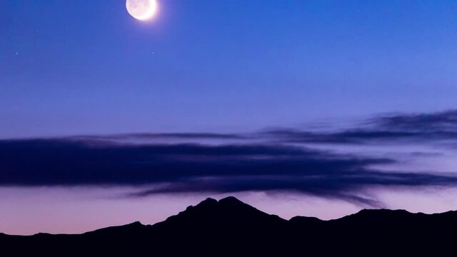4K Twilight Moon Set In Deep Dark Blue Sky Over The Black Silhouette Mountain Range and Narrow Clouds Landscape After Sunset Timelapse With Canon 6D Night Sky Modified Evening Photography