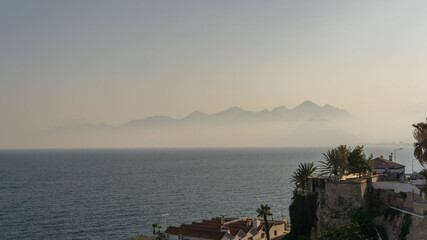 house on a cliff with mountains in the background, summer