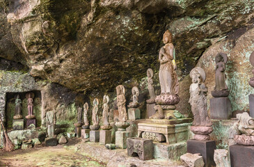 Fototapeta na wymiar Buddhist statues of deities and monks surrounding the sculpture of Saigoku Kannon bodhisattva created in 18th century by Jingoro Eirei Ono in the Mount Nokogiri.