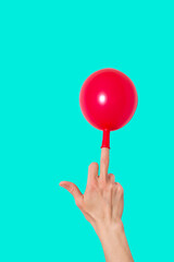 Cheerful  hand with a red balloon on the middle finger . Isolated on background.