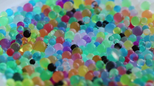 Orbizes rotate in different directions. Decoration of water balls with hydrogel - orbeez.