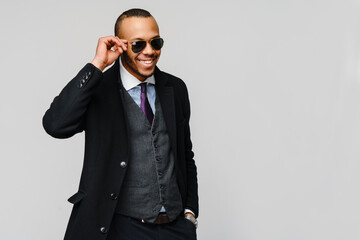 studio shot of a african-american businessman wearing coat over light grey background