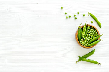 Bowl of green pea pod with beans on kitchen desk. Top view