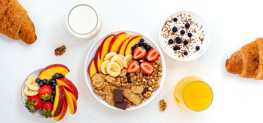 A light summer breakfast with dairy products, cereals, berries and croissants. Flatly. Banner.