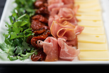 Plate with prosciutto cheese and sun-dried tomatoes