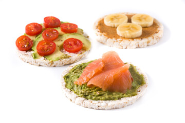 Assortment of ingredients on puffed rice cakes isolated on white background	