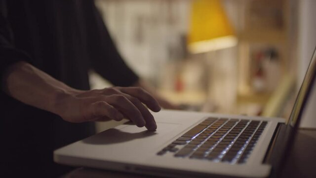 Close-up slow motion shot footage of unrecognizable man wearing black sweater using his laptop