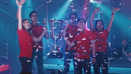 Diverse Esport Team Winner of the Video Games Tournament Celebrates Victory Cheering and Lifting Trophy in Big Championship Arena. Pro Cyber Gaming Event with Gamers, Fans and Spectators Having Fun