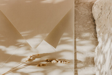 Craft envelope, blank greeting card, stone and wheat branch on a marble table. Flat lay, top view. Rustic autumn composition. 