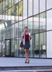 Business woman talking on phone and drinking coffee outdoor