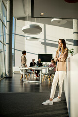 Casual young woman in a busy modern workplace