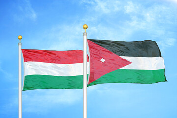 Hungary and Jordan two flags on flagpoles and blue cloudy sky