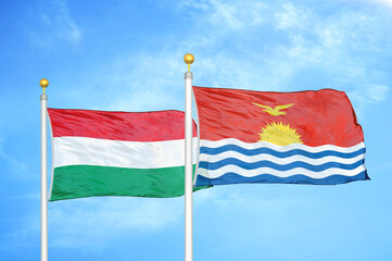 Fototapeta na wymiar Hungary and Kiribati two flags on flagpoles and blue cloudy sky