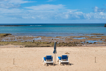 Fototapeta na wymiar Beach chairs on the white sandy beach