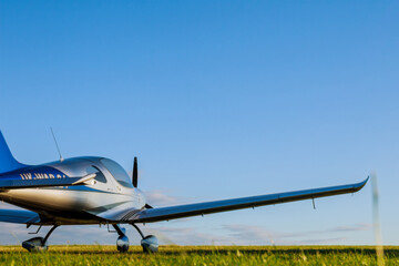 Blur Light small plane on the grass on a background of blue clouds