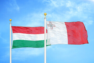 Naklejka na ściany i meble Hungary and Malta two flags on flagpoles and blue cloudy sky