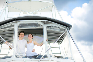 bride and groom in white clothes travel on yacht.