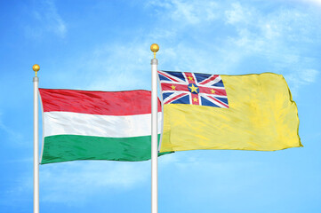 Hungary and Niue two flags on flagpoles and blue cloudy sky