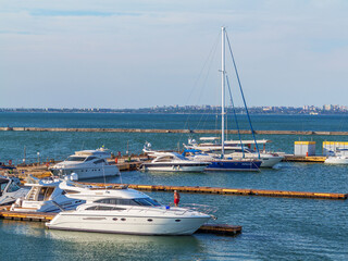 Obraz premium Odessa, Ukraine July 6, 2016: Yacht Club with parked vehicles of various models. Pleasure boat with tourists depart from the pier in Odessa, Ukraine, July 6, 2016