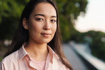 Image of pleased asian beautiful girl looking at camera