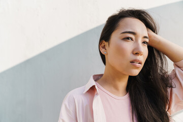 Image of pleased asian beautiful girl looking aside