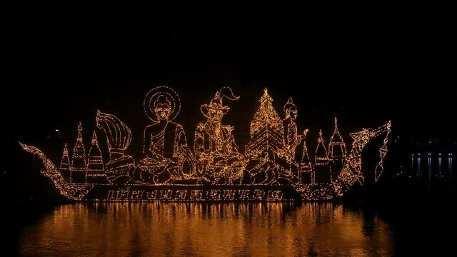 Traditional fire boat floating in Mekong river at night in Nakhon Phanom, Thailand