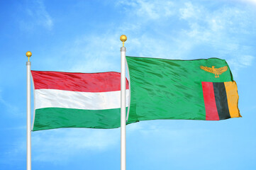 Hungary and Zambia two flags on flagpoles and blue cloudy sky