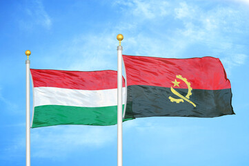 Hungary and Angola  two flags on flagpoles and blue cloudy sky