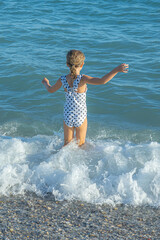 Little girl goes swimming in the mediterranean sea.