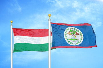 Hungary and Belize  two flags on flagpoles and blue cloudy sky