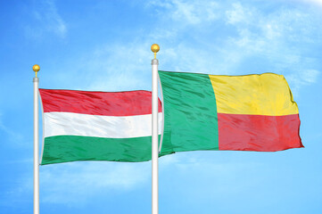 Hungary and Benin  two flags on flagpoles and blue cloudy sky