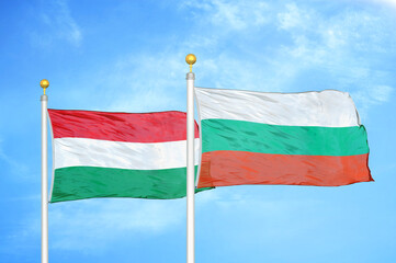 Hungary and Bulgaria  two flags on flagpoles and blue cloudy sky