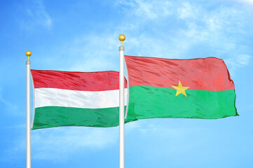 Hungary and Burkina Faso  two flags on flagpoles and blue cloudy sky