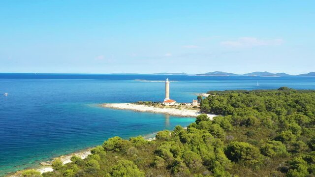 Old lighthouse of Veli Rat on the shore on the island of Dugi Otok, Croatia, beautiful seascape horizon in background, drone revel footage