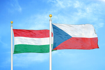 Hungary and Czech Republic two flags on flagpoles and blue cloudy sky