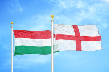 Hungary and England two flags on flagpoles and blue cloudy sky
