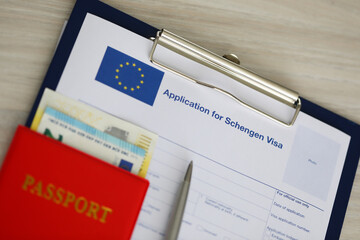 On the table is an application for a Schengen visa. Submission of documents and payment of visa fee