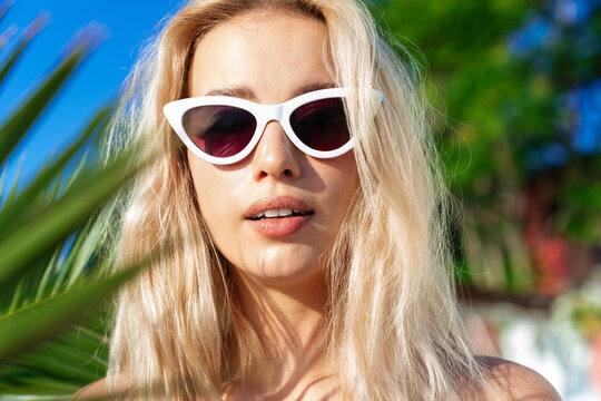 Image of charming blonde woman in sunglasses looking at camera
