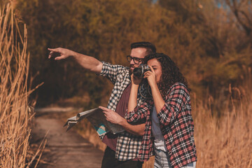 Couple taking photos and reading a map while hiking