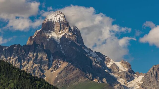 4K Moving Clouds Time Lapse Over The Single Snow Mountain Peak Ushba, The Georgia Nature Alps Matterhorn Near The Mestia Ushguli And Shkhara Mt. Russia Border In Summer Cool Blue Sky Sunset Daytime