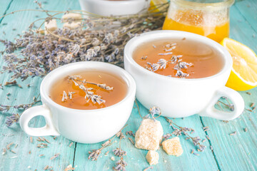 Aromatic lavender tea cup, with and bunch of lavender, honey and lemon, turquoise wooden background copy space
