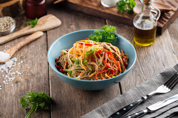 Funchoza noodle salad with stripes of vegetables