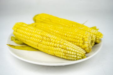 boiled sweet corn on a white plate