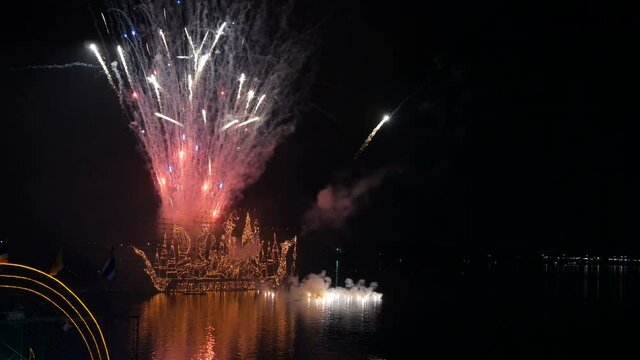 Traditional fire boat floating with firework in Mekong river at night in Nakhon Phanom, Thailand