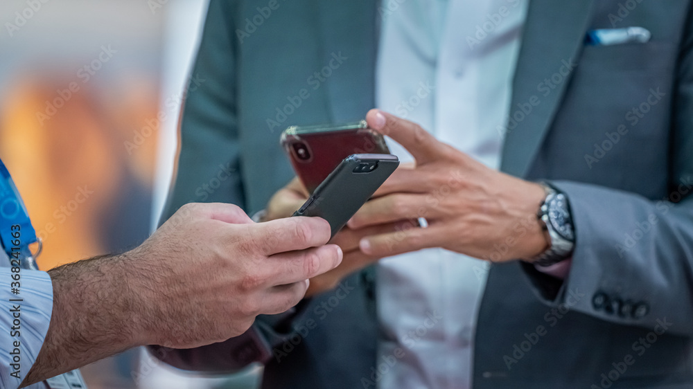 Poster trader using smartphone at trade fair