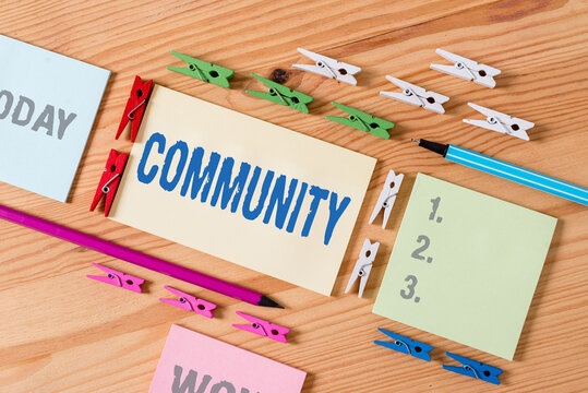 Word writing text Community. Business photo showcasing group of showing with a common characteristics living together Colored clothespin papers empty reminder wooden floor background office