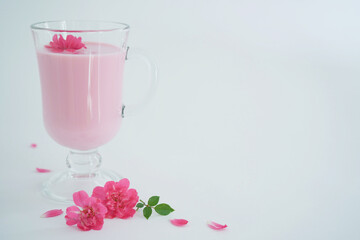 Rose moon milk for a better sleep with copy space. Ayurveda warm drink consumed before bed. Nice in case of sleeplessness. White background,close-up