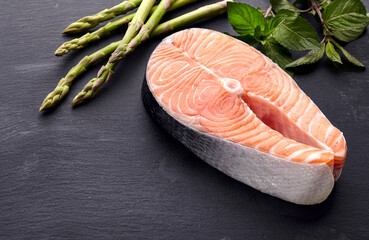 Salmon fish on the black background with asparagus and mint.  Steak on black background.