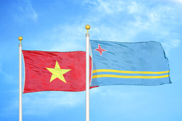Vietnam and Aruba two flags on flagpoles and blue sky